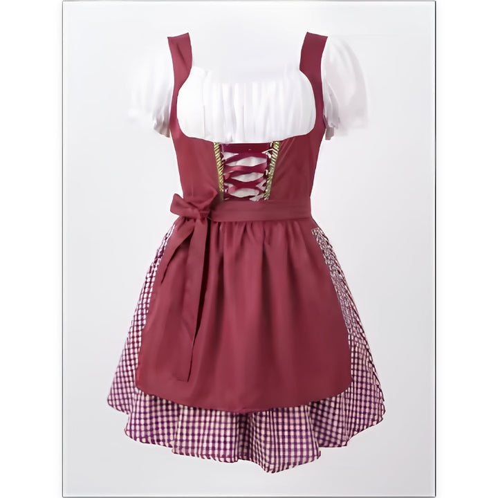 Voorkant van de bordeauxrode dirndl op een pop, met wit blouseachtig bovenstuk, veterdetail, strik en geruite onderrok. 1