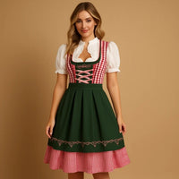 Model draagt een groene dirndl met rood-wit geruit lijfje, roze veters en geruite onderrok, gecombineerd met een witte blouse. 5