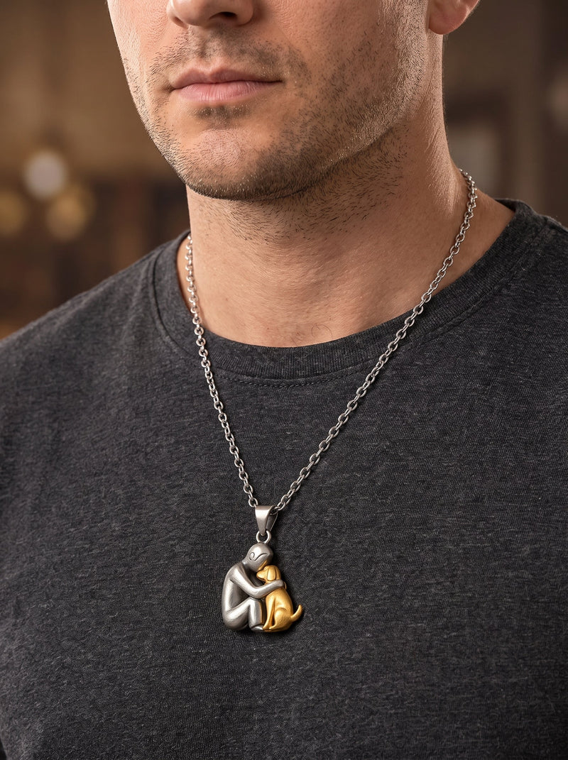 Man in donkergrijs t-shirt draagt de ketting met mat zilverkleurige hanger van figuurtje en goudkleurige hond. 11