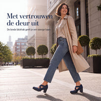Lachende vrouw loopt door een stadsstraat in beige trenchcoat, spijkerbroek en marineblauwe schoenen met blokhak. 3