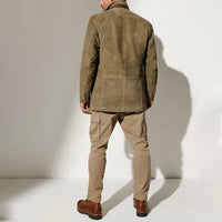 Achterkant van de olijfgroene jas, gedragen door een model met beige cargobroek en bruine leren laarzen. 3