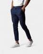 Model draagt de donkerblauwe slim fit broek met elastische tailleband en witte sneakers 2