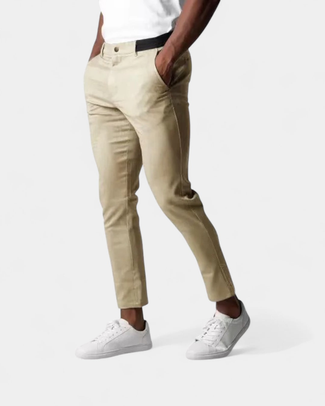Model draagt de beige slim fit broek met handen in de zakken en witte sneakers 3