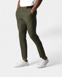 Model draagt de olijfgroene slim fit broek met elastische tailleband en witte sneakers 4