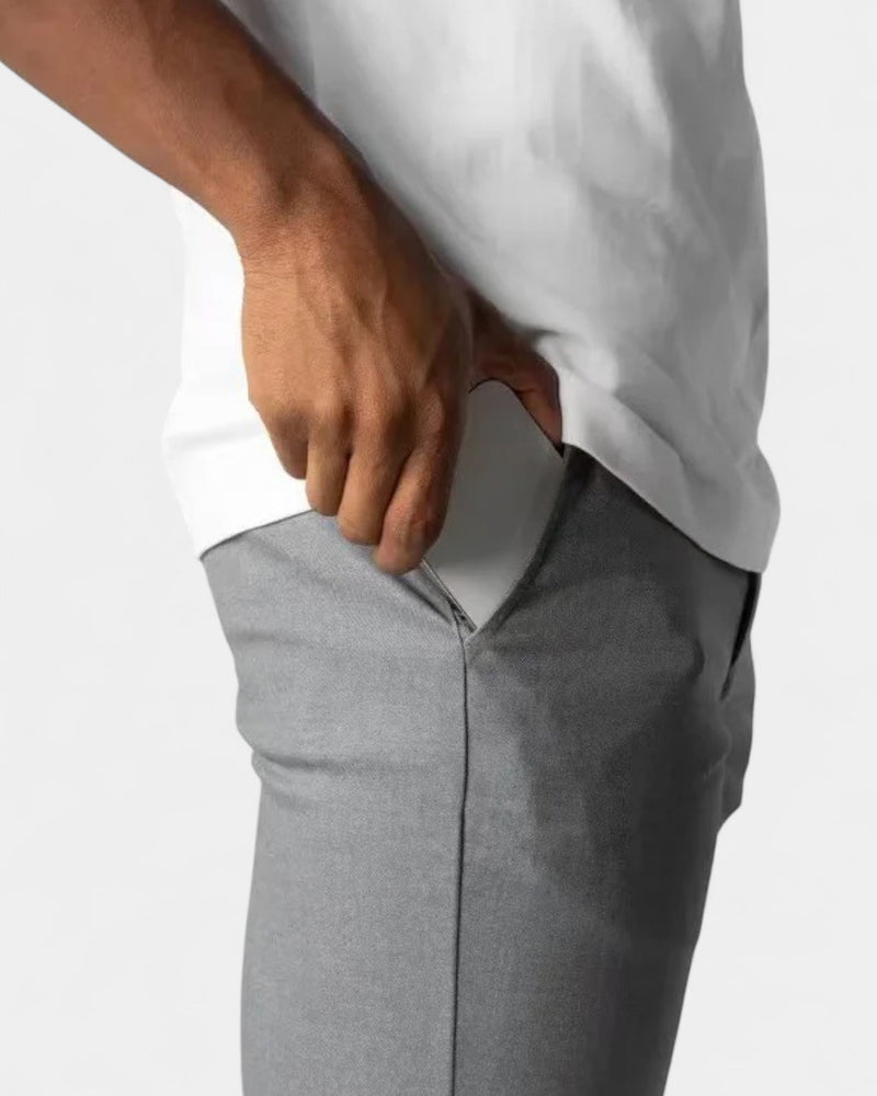Close-up van de heup van de grijze broek, met een hand die in de zak gaat 6