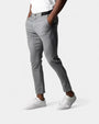 Model draagt de grijze slim fit broek met handen in de zakken en witte sneakers 1