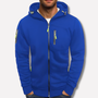 Koningsblauwe hoodie met capuchon en limoengroene ritstrekkers op een effen lichte achtergrond, gedragen door een man met handen in de zakken. 2