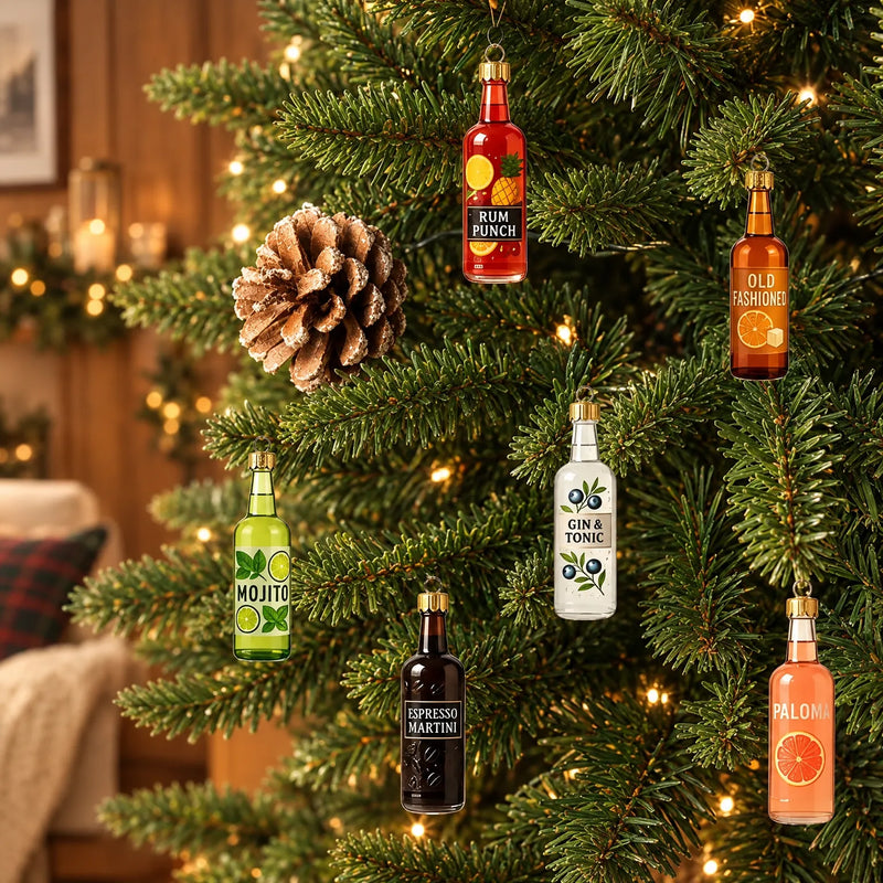Zes gekleurde flesjes als kerstbal in een verlichte kerstboom, naast een dennenappel, met een gezellige woonkamer op de achtergrond. 1