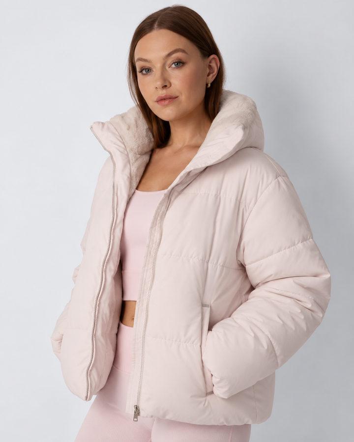 Model in roze pufferjack met opstaande kraag, handen in de zakken en fleece voering zichtbaar 7