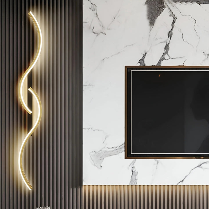 Gouden golvende wandlamp op een donkere lamellenwand naast een tv tegen een marmeren wand 3