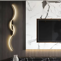 Zwarte golvende wandlamp op een donkere lamellenwand naast een tv tegen een marmeren wand 5