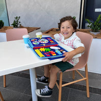 Lachend jongetje aan een tafel met het opengeklapte blauwe activiteitenboek ervoor 7