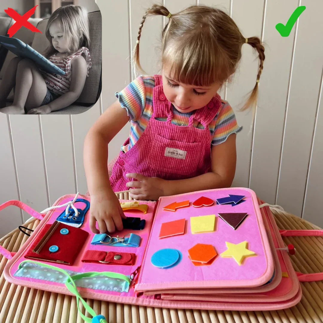 Meisje met staartjes speelt aan het roze boek met vormen, gespen en veters 4