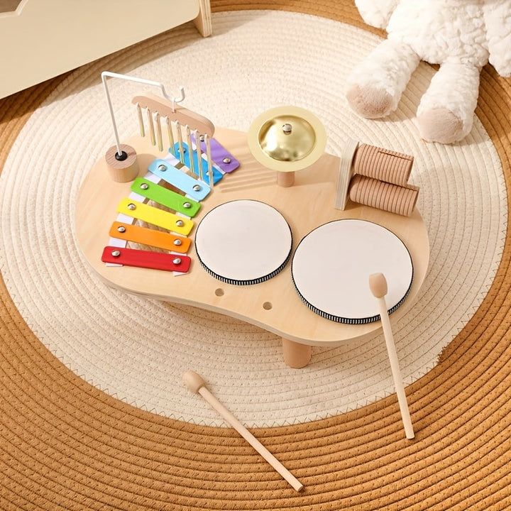 Muziektafel van bovenaf op een rond gevlochten kleed, met twee houten stokjes die voor de trommels op de grond liggen. 8