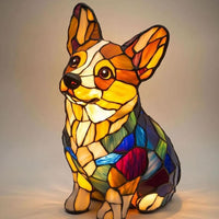 Zittende corgi-lamp met grote oren en kleurrijke glas-in-lood-vlakken, van voren gezien met een warme gloed op een lichte ondergrond. 24