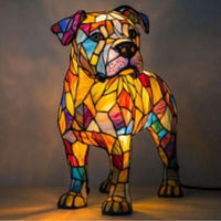 Staande bulldog-lamp in glas-in-lood-stijl met hangende oren en veelkleurige gloeiende vlakken, met een zwart snoer rechts onderin. 29