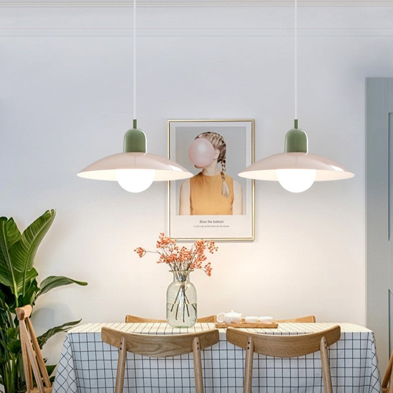 Twee hanglampen met groene fitting en lichte kap boven een eettafel met houten stoelen en bloemen 5