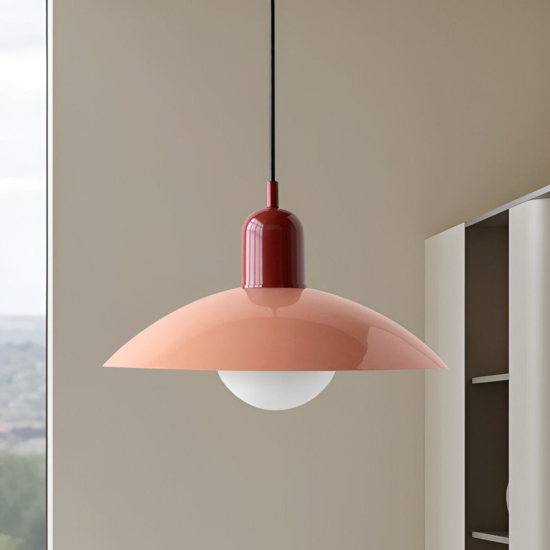 Close-up van een hanglamp met donkerrode fitting en perzikroze kap naast een raam en kast 11