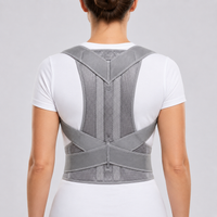 Vrouw van achteren in een wit shirt met de grijze houdingbrace, schouderpanelen en gekruiste banden goed zichtbaar. 2