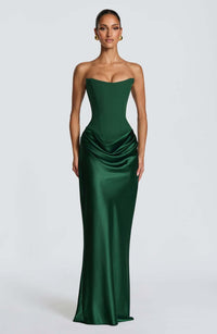 Model in smaragdgroene strapless korsetjurk met satijnen rok, frontaal tegen lichtgrijze achtergrond 1