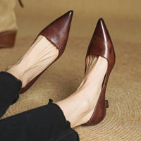 Bruine leren pumps met spitse neus aan de voeten van een model, zwarte broek, gevlochten ondergrond 21