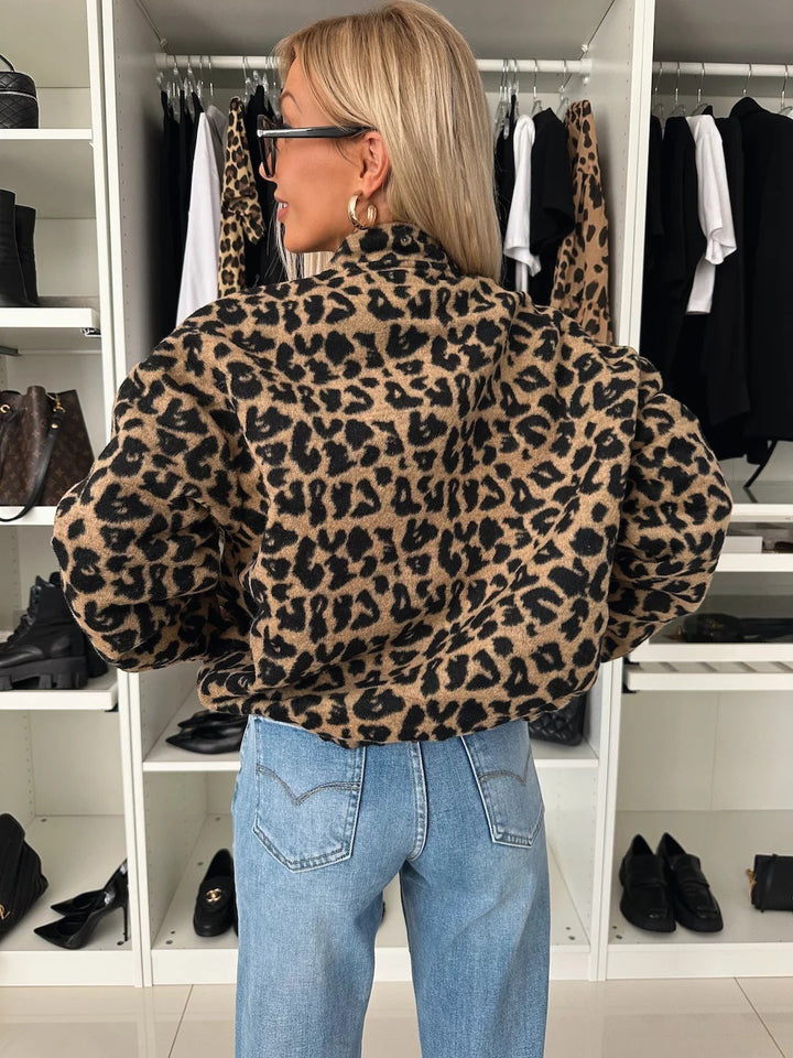 Achterkant van het jasje met luipaardprint, gedragen door een model met blond haar en een lichtblauwe jeans. 2