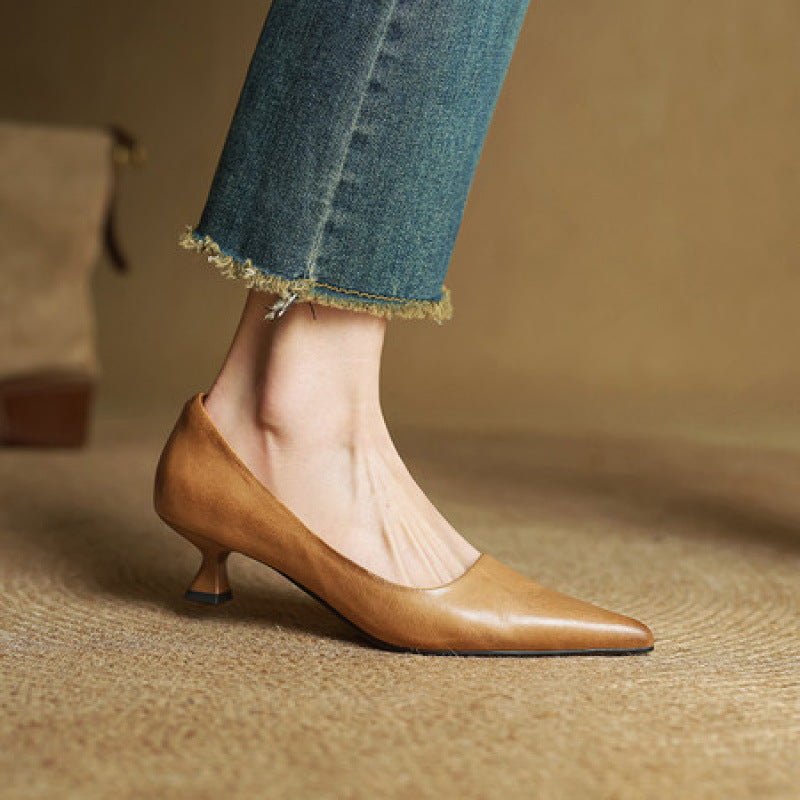 Zijaanzicht van een lichtbruine pump aan een voet in een jeans met rafelige pijpen 4