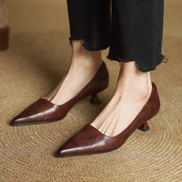 Bruine pumps gedragen met zwarte broek met rafelrand, beide schoenen staand op een gevlochten ondergrond 18