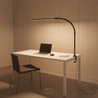 Zwarte lamp met warm licht geklemd aan de rand van een wit bureau met laptop en stoel 7