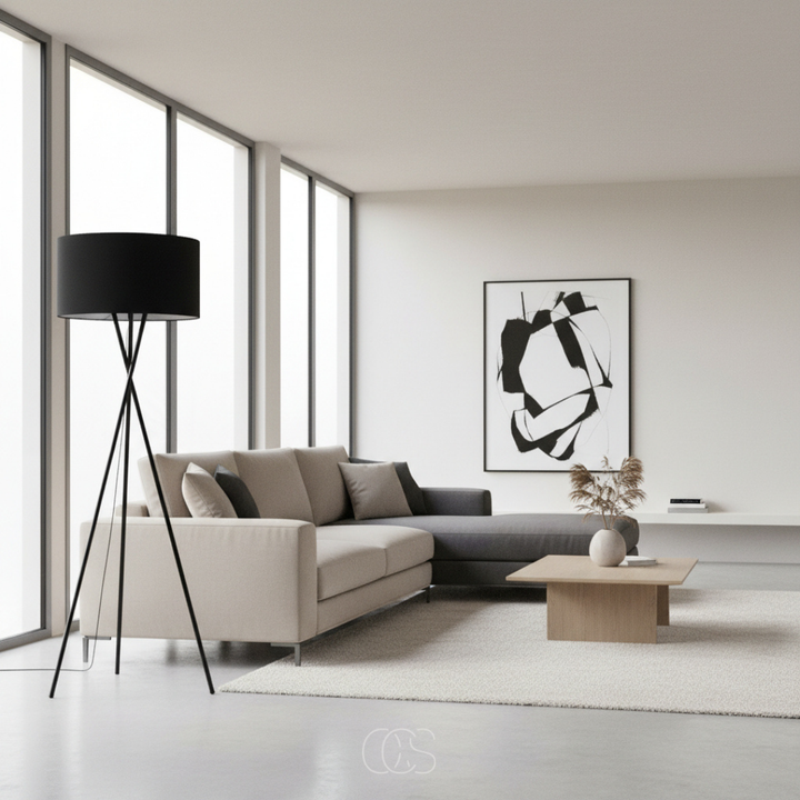 Zwarte statieflamp met ronde kap naast een beige hoekbank in een lichte, minimalistische woonkamer 1