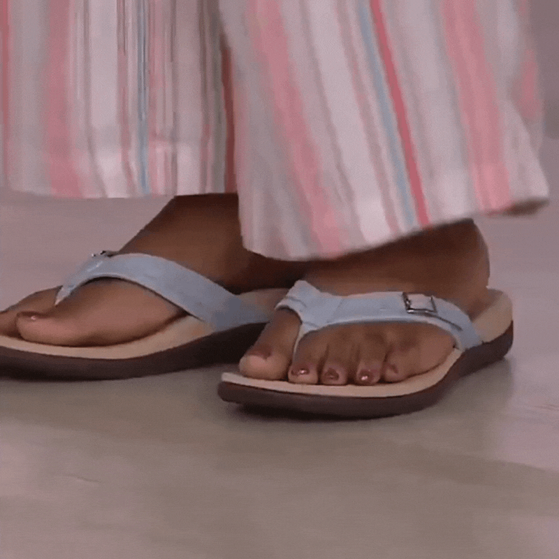 Model draagt lichtblauwe teensandalen met gesp onder een gestreepte wijde broek 16