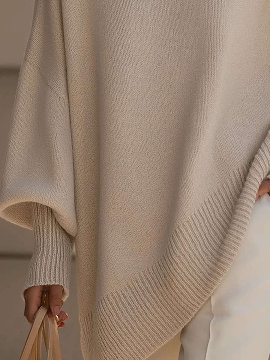 Detail van de geribde, schuin aflopende zoom en de brede mouw met geribde manchet in beige. 3