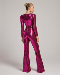 Achterkant van de fuchsia roze pailletten jumpsuit aan een model, met rugnaad, lange mouwen, tailleband en uitlopende pijpen. 2