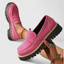 Roze loafers met stevige profielzool, de ene vastgehouden in de hand, de andere gedragen 3