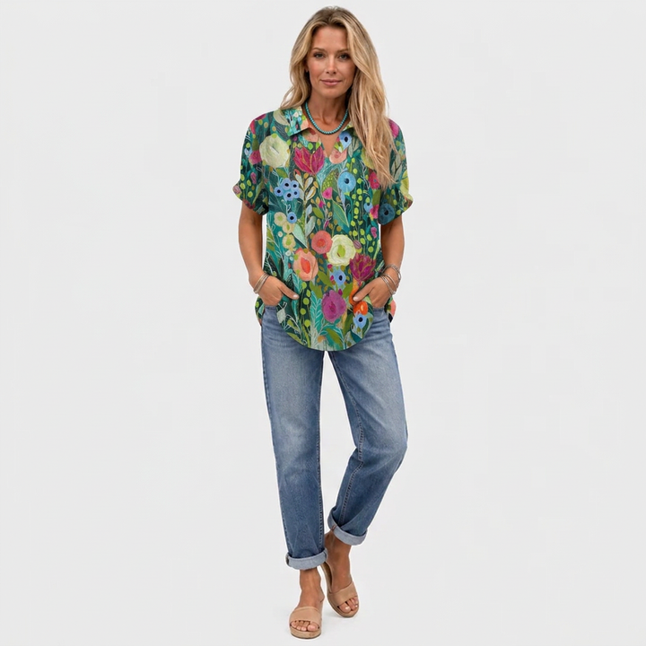 Model in volledige outfit draagt de bloementop met kraag, spijkerbroek en sandalen, van voren gezien 2