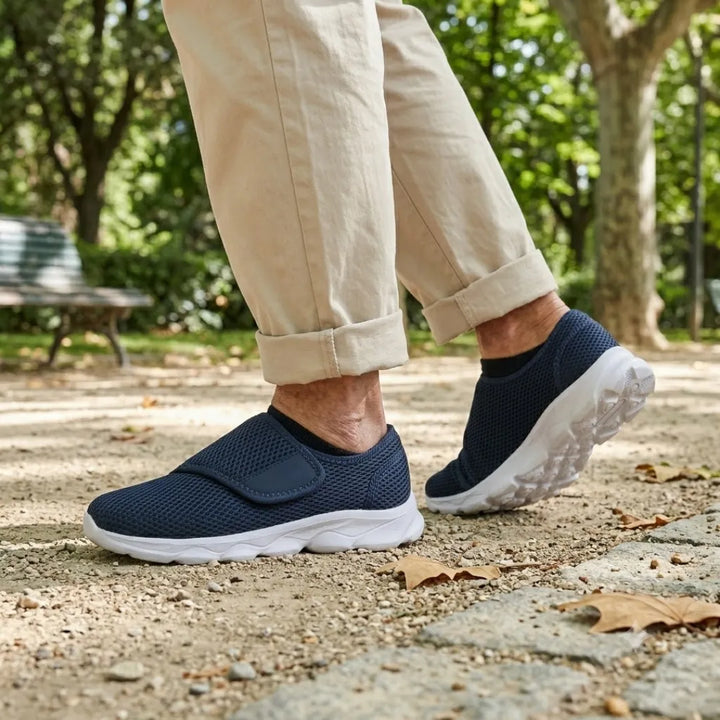 Donkerblauwe mesh schoenen met klittenband gedragen tijdens een wandeling over een grindpad in het park, met beige broek. 2