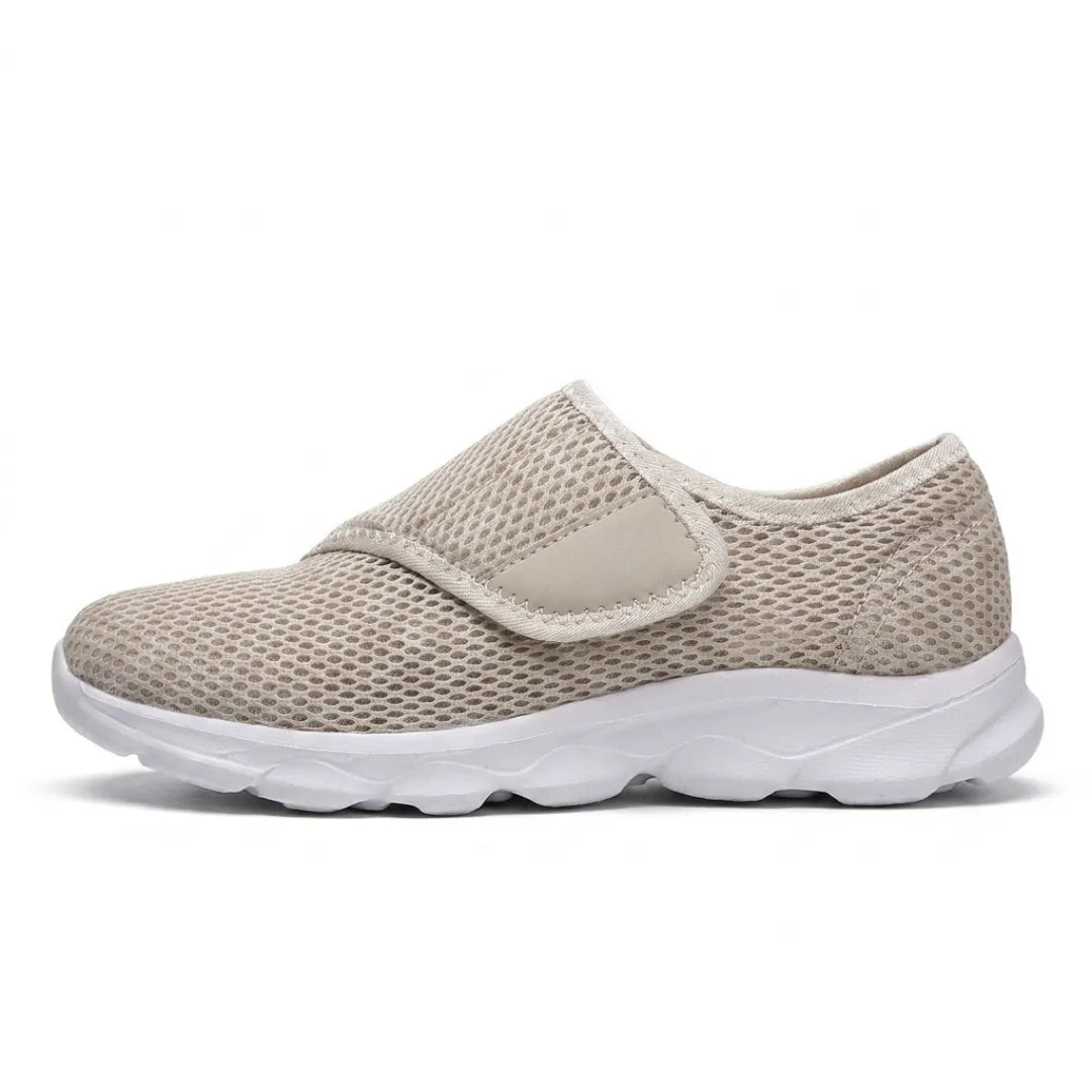 Beige mesh schoen met witte zool en klittenbandsluiting, zijaanzicht op effen witte achtergrond. 28