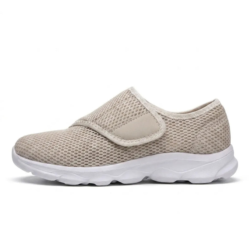 Beige mesh schoen met witte zool en klittenbandsluiting, zijaanzicht op effen witte achtergrond. 28