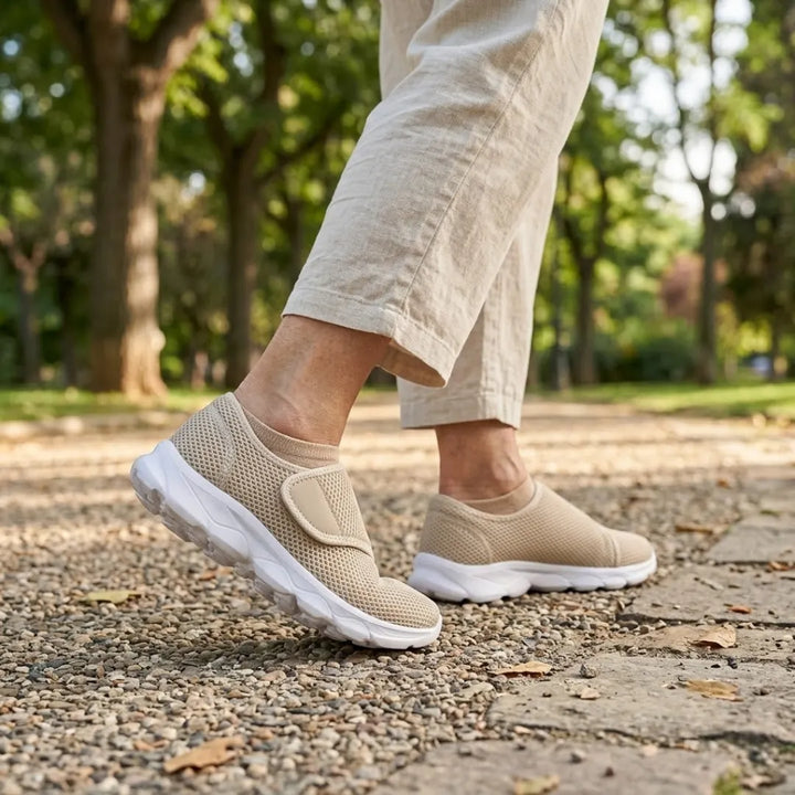 Beige mesh schoenen met klittenband gedragen tijdens het wandelen op een grindpad in een park, met lichte linnen broek. 29