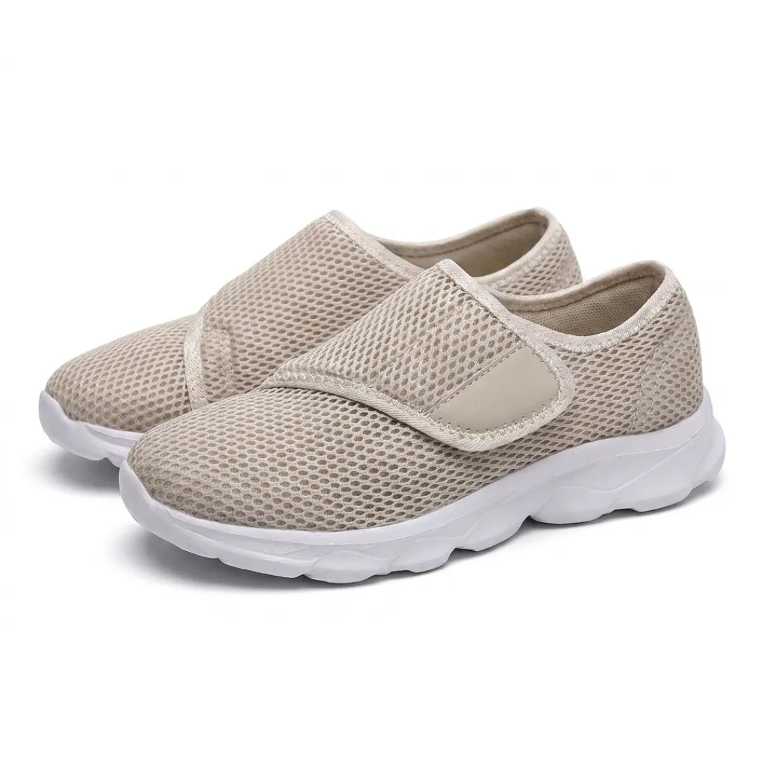Paar beige mesh schoenen met witte zool en klittenbandsluiting, schuin van voren gefotografeerd. 34