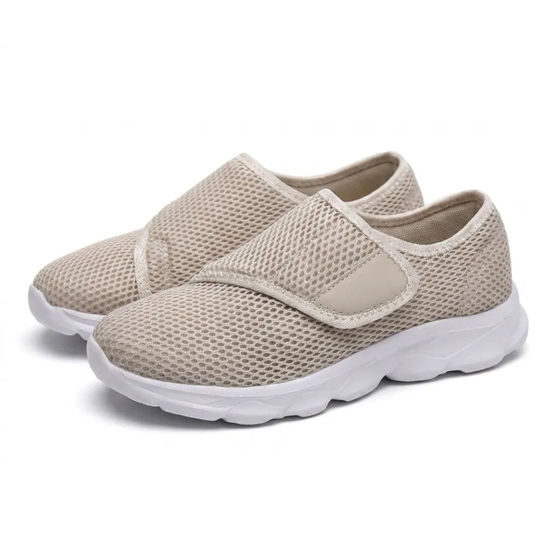 Paar beige mesh schoenen met witte zool en klittenbandsluiting, schuin van voren gefotografeerd. 34