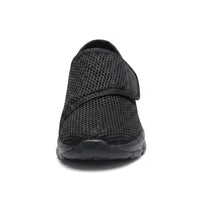 Vooraanzicht van de zwarte mesh schoen met brede neus en klittenbandstrap over de wreef. 17