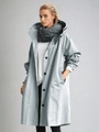 Model draagt de lichtgrijsblauwe trenchcoat met glanzende stof, capuchon en knopen, met een hand in de zak. 5