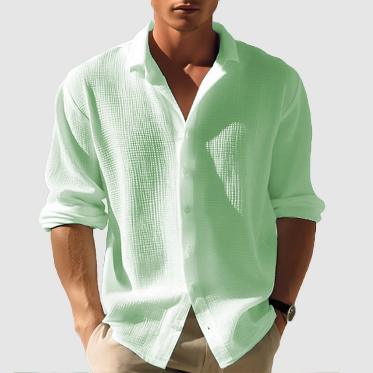 Model draagt het gestructureerde overhemd in lichtgroen, relaxed gedragen met opgerolde mouwen en een beige broek. 3