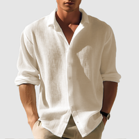 Model draagt het gestructureerde overhemd in gebroken wit of crème, met opgerolde mouwen en een beige broek. 5
