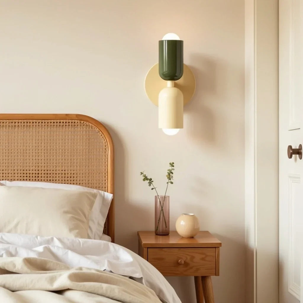Wandlamp in donkergroen en crème boven een nachtkastje naast een bed met rotan hoofdeinde en beige beddengoed. 13