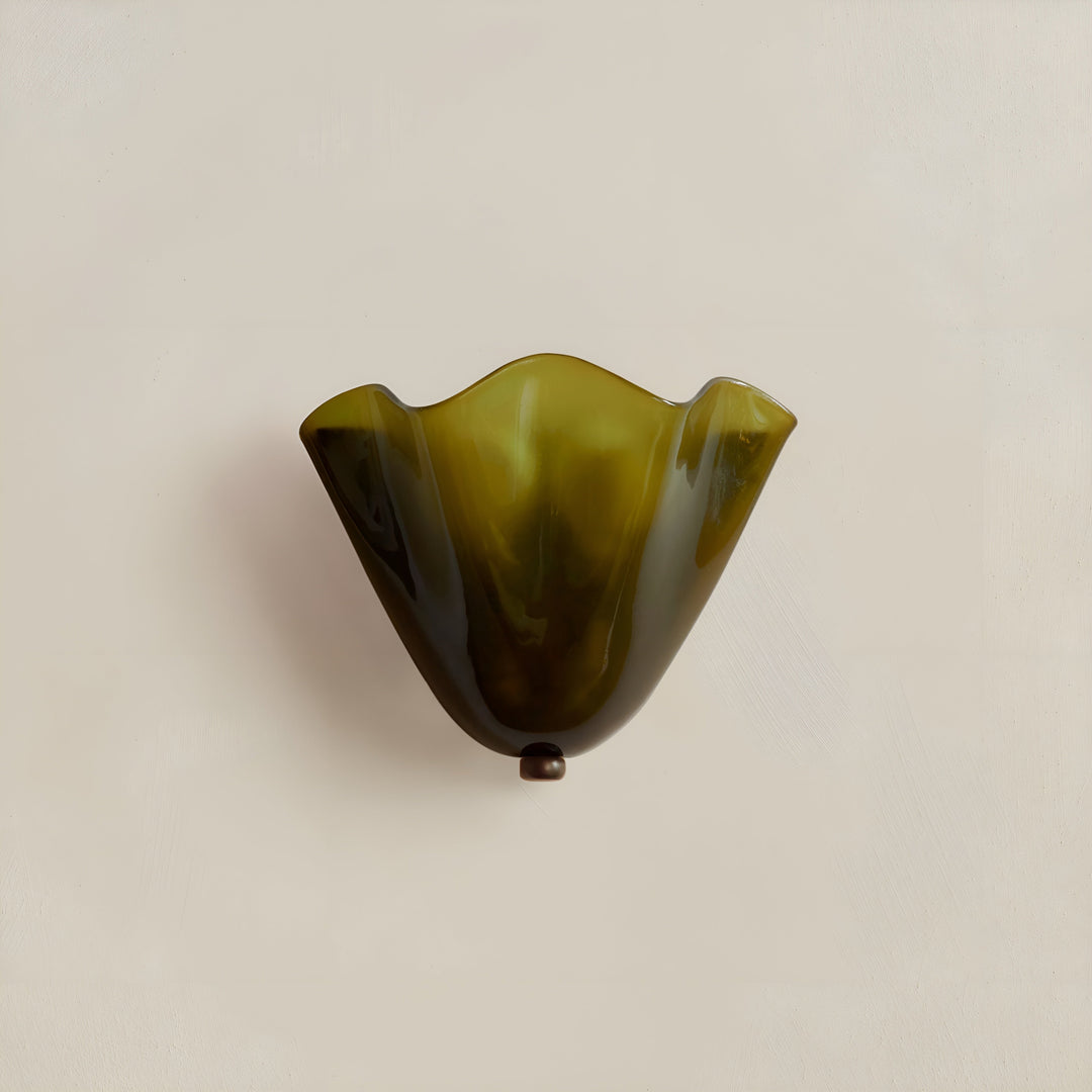 Olijfgroene glazen wandlamp met golvende rand en klein metalen knopje onderaan, uitgeschakeld tegen een effen lichte muur. 6