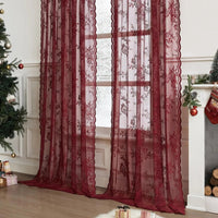 Twee donkerrode doorzichtige kantgordijnen met bloemenpatroon voor een raam, in een kamer met kerstboom en open haard. 2