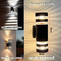 Ronde zwarte cilinderwandlamp met doorzichtige banden en maataanduiding, met voorbeeldfoto's van koud wit en warmer licht tegen een buitenmuur. 9