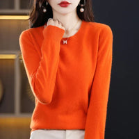 Model in een feloranje trui met ronde hals, een hand tegen de kraag 5